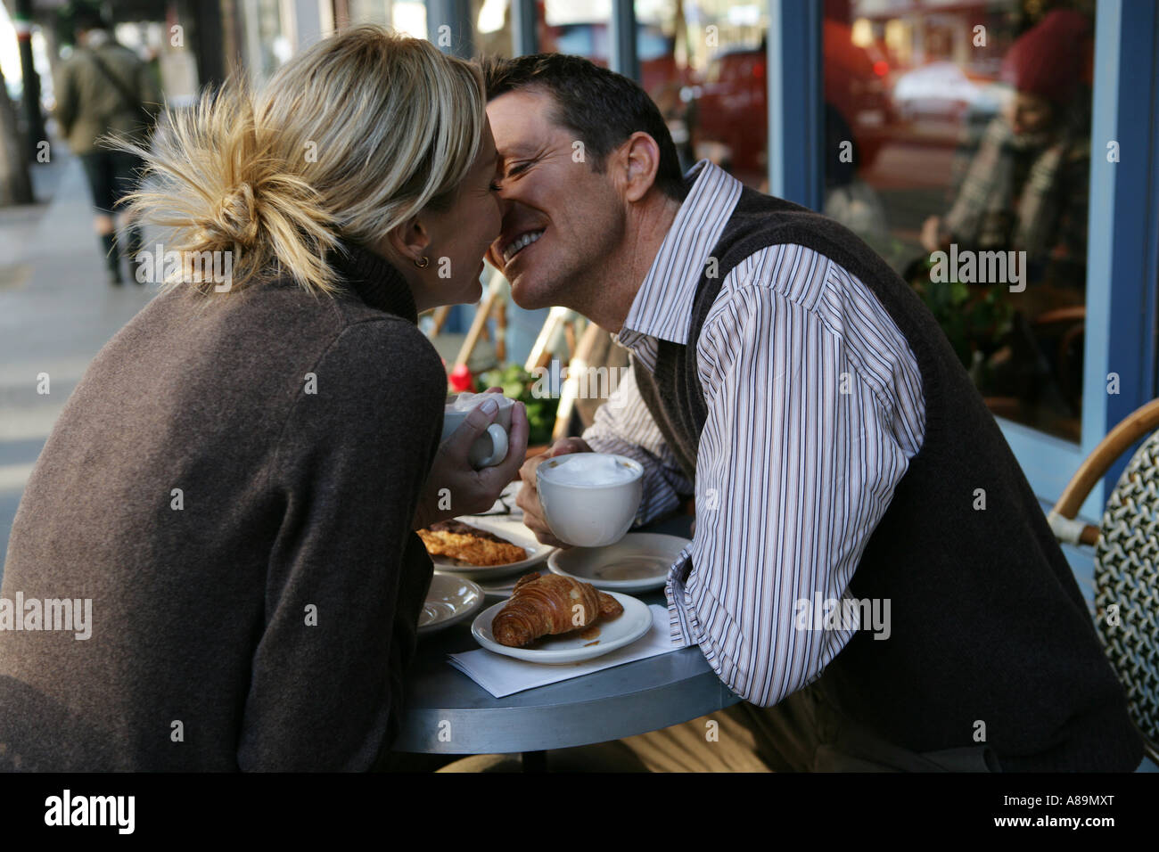 Mature couple kissing at an outdoor cafe Stock Photo