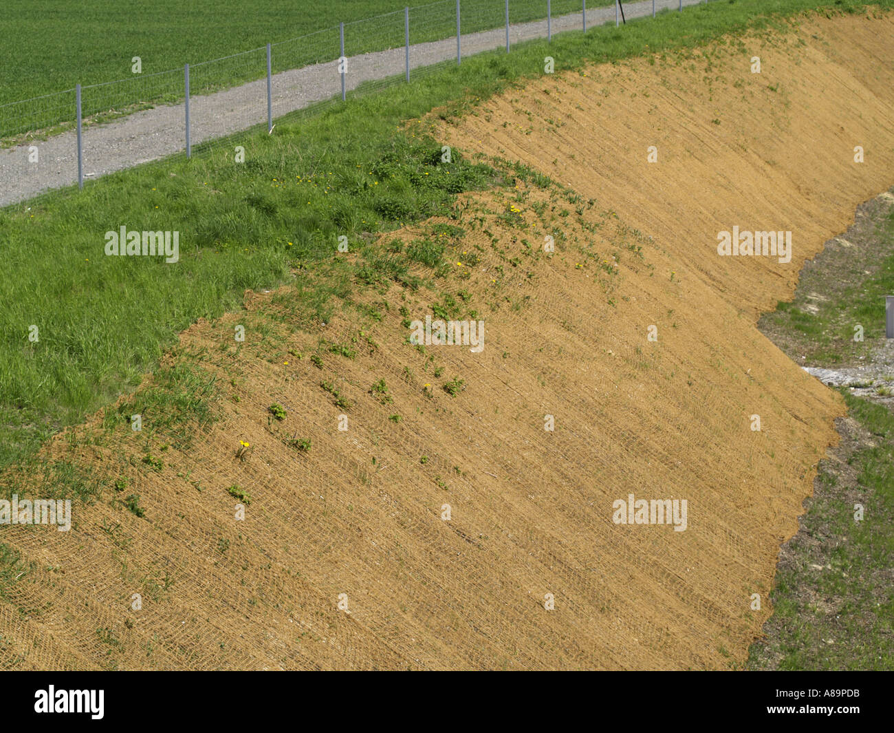 slope with brown earth and gravel walk, slope fixing with jute net Stock Photo