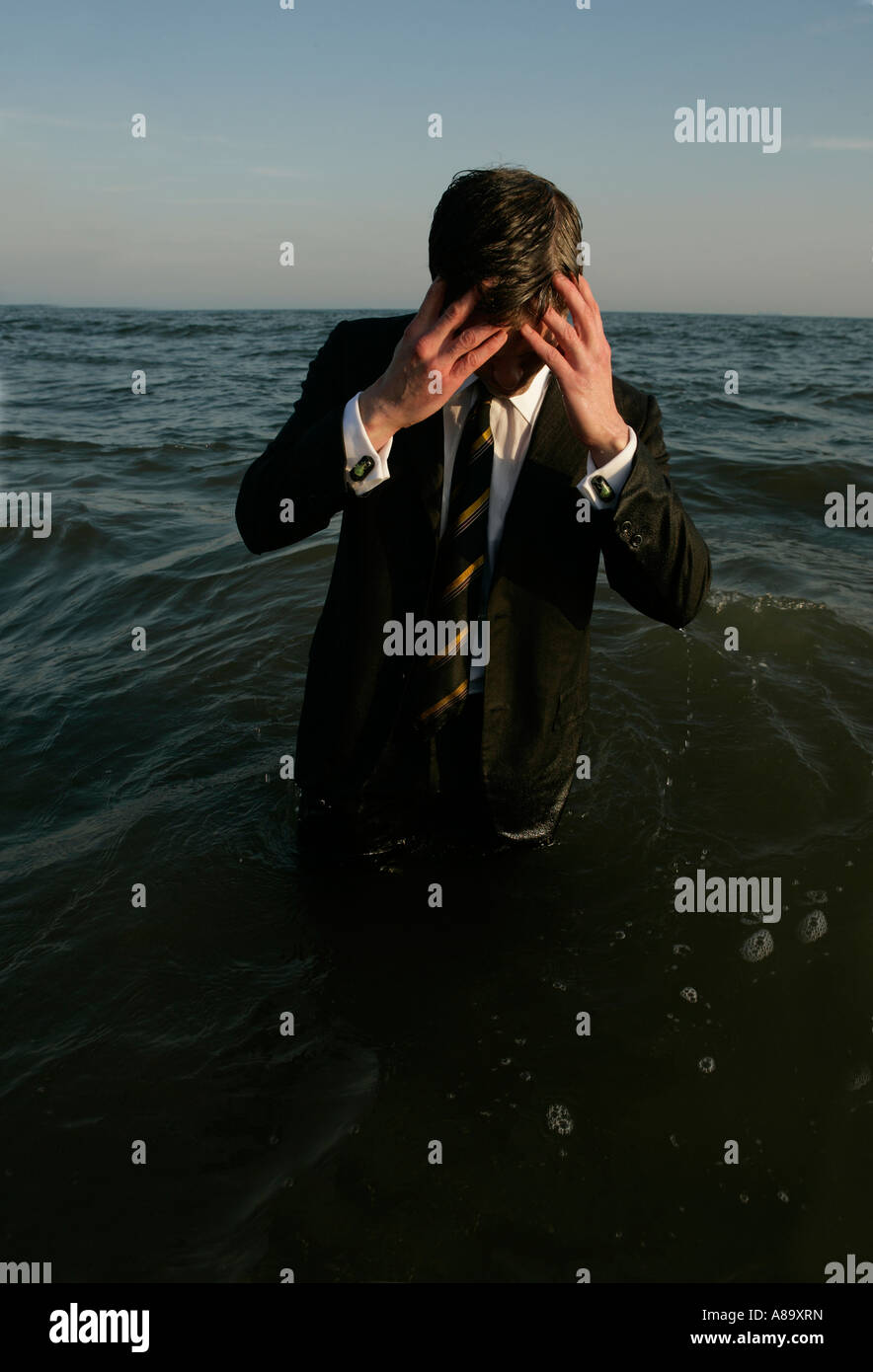 Man in a suit, waist high in water with his hands on his head Stock ...