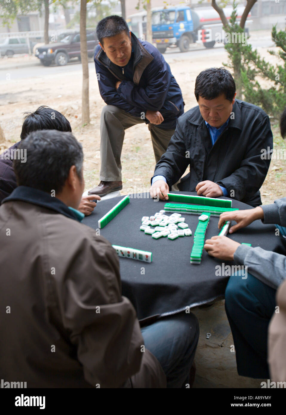 CHINA BEIJING Chinese men playing mahjong a traditional Chinese game of skill and luck using tiles Stock Photo