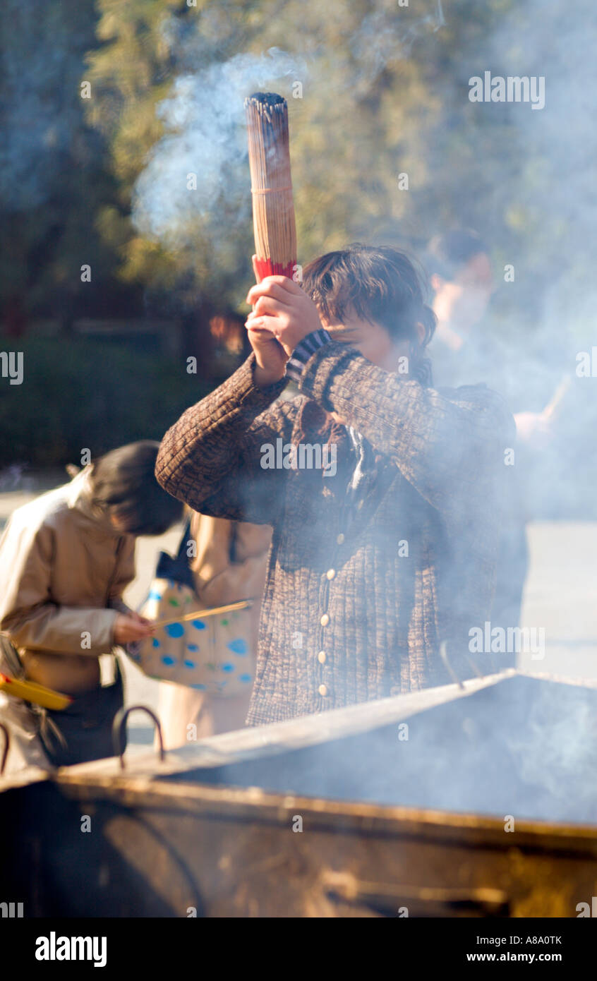 CHINA BEIJING Chinese Buddhists burn incense and pray outside the Palace of Peace and Harmony Yonghegong Lama Temple Stock Photo