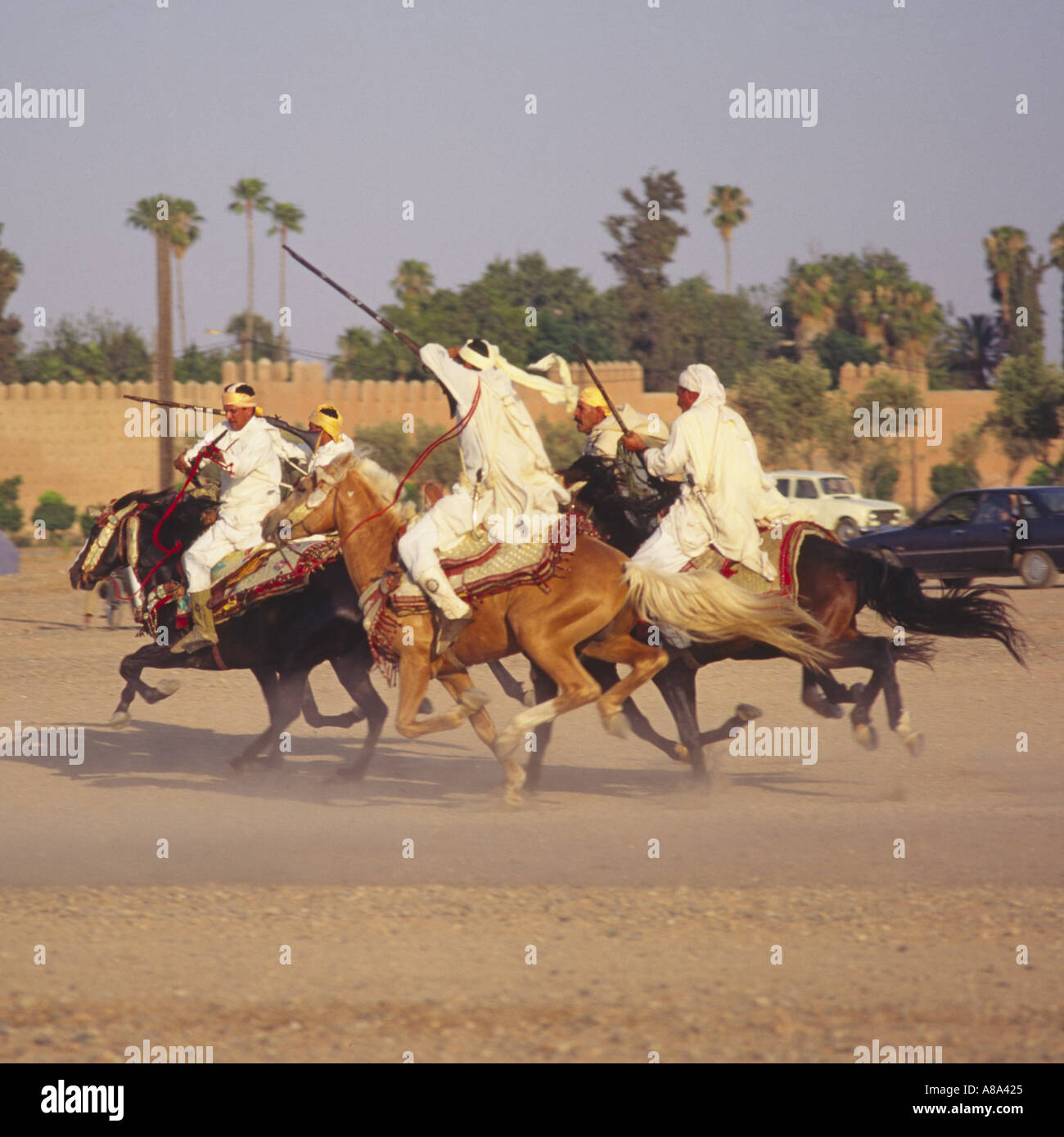 Group of galloping charging horsemen with rifles at a National Festival of Popular Art in Marrakech Morocco Stock Photo