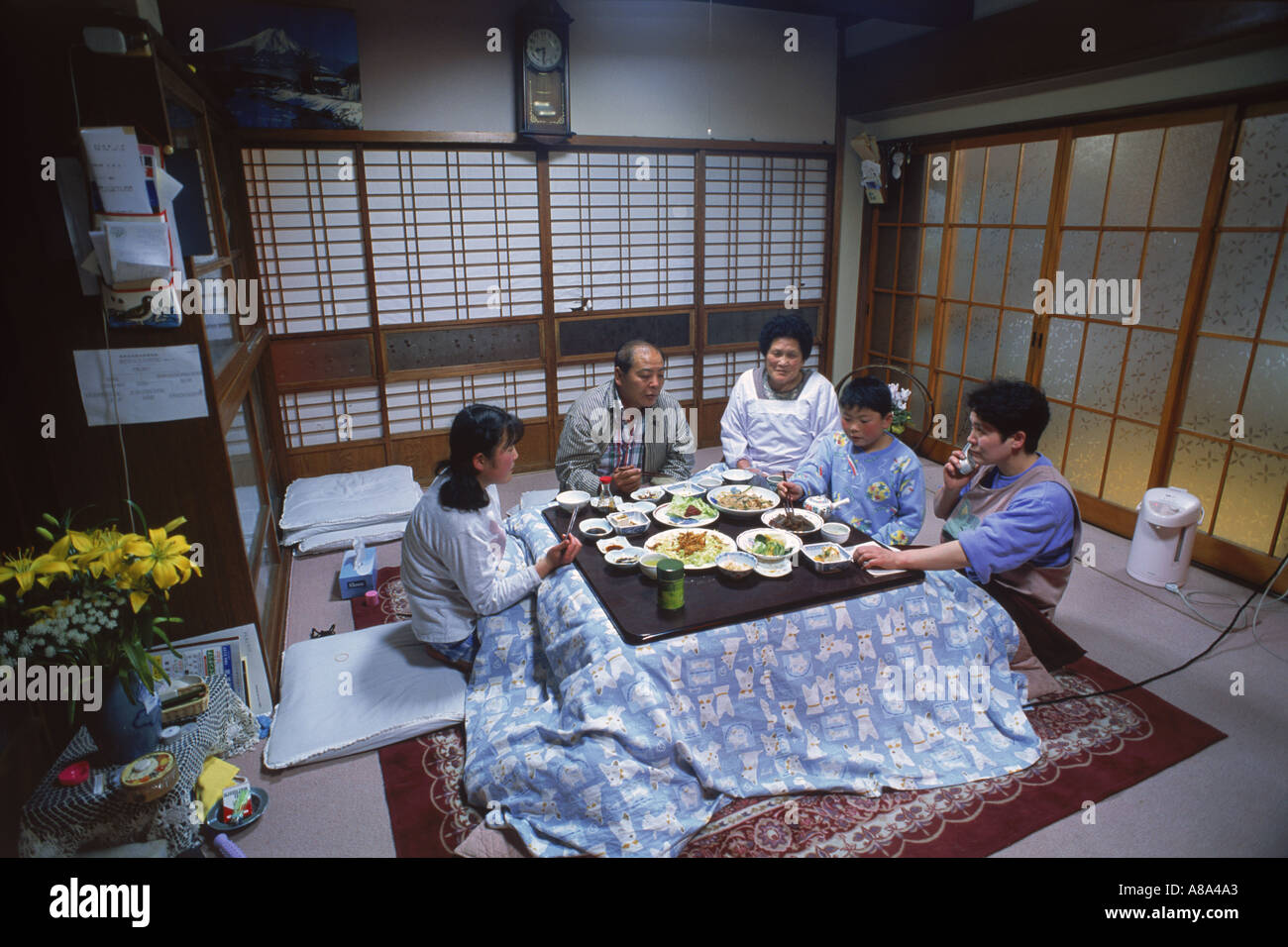 Family eating dinner in main room of  typical Japanese home in Kyoto Stock Photo