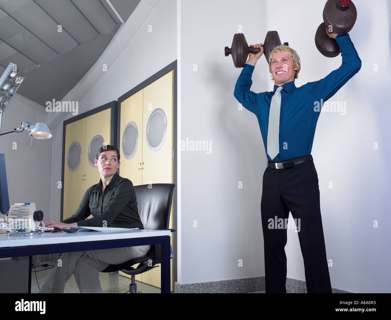 Office worker lifting weights Stock Photo