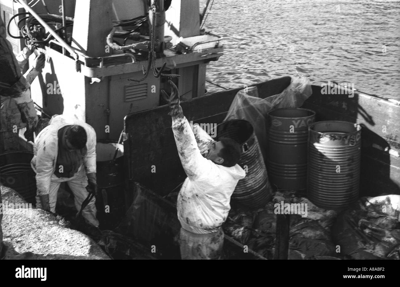 PRESTIGE OIL SPILL Fishermen in protective overalls winch recovered oil