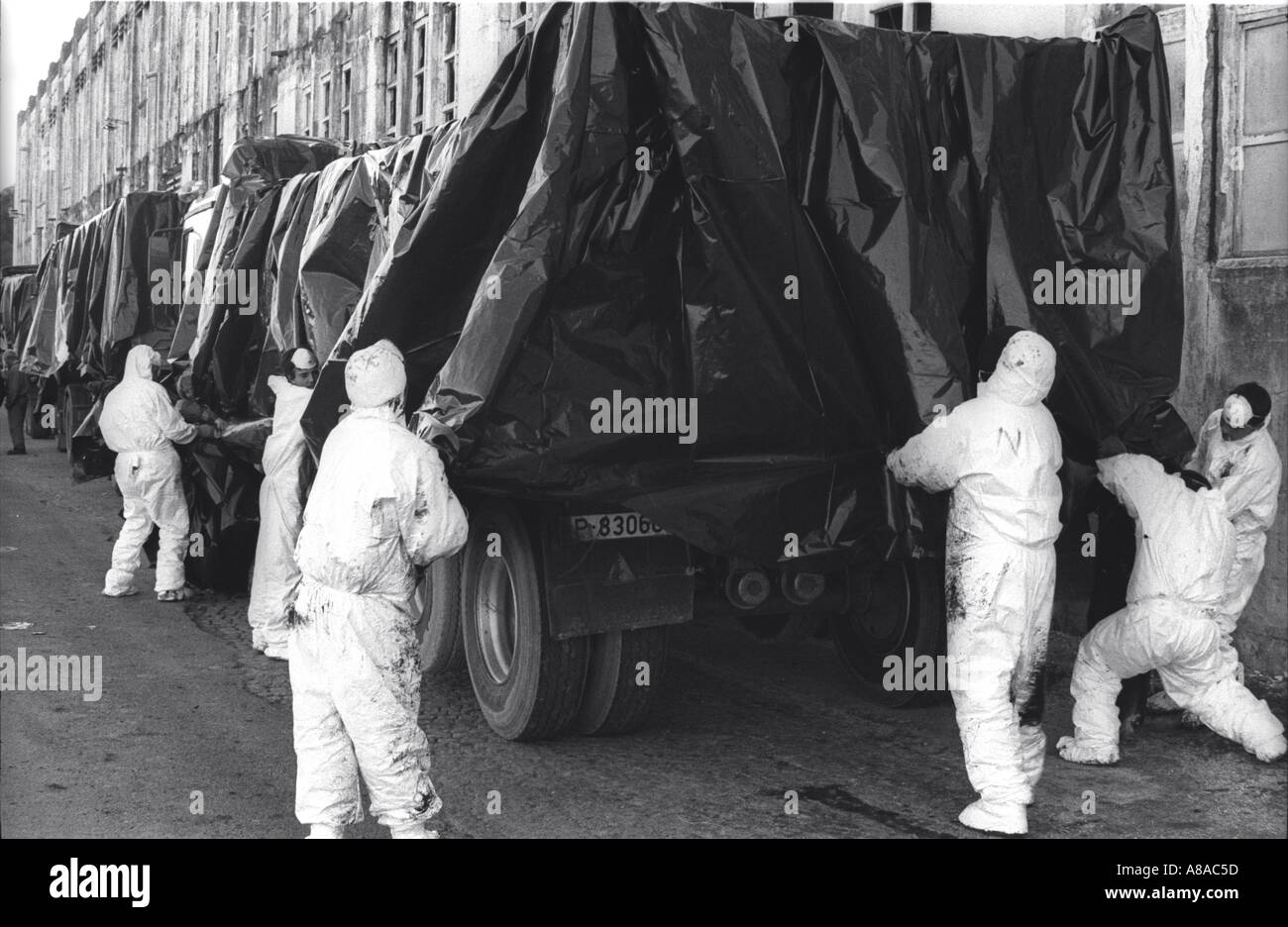 PRESTIGE OIL SPILL Volunteers in protective clothing protect the trucks