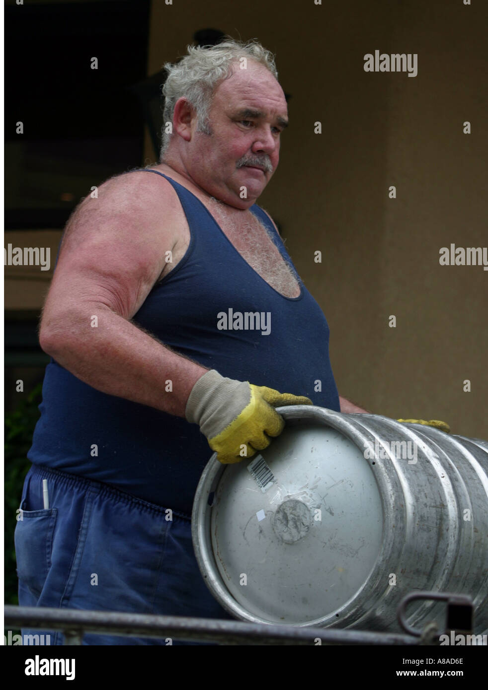 A beer delivery driver carries a beer barrel Stock Photo Alamy