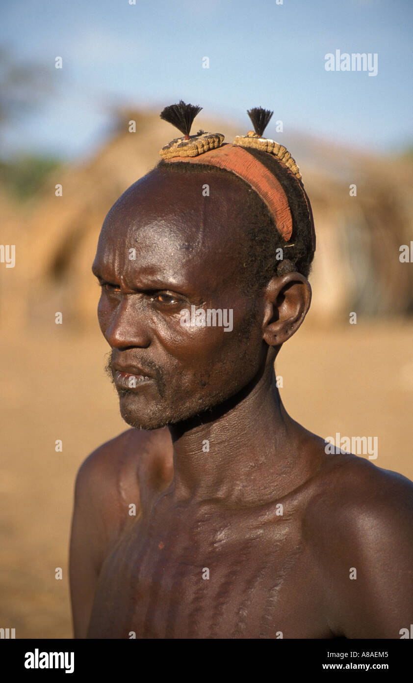 Dasanesh man with body scarring and clay hair bun , Omorate , South Omo valley , Ethiopia Stock Photo