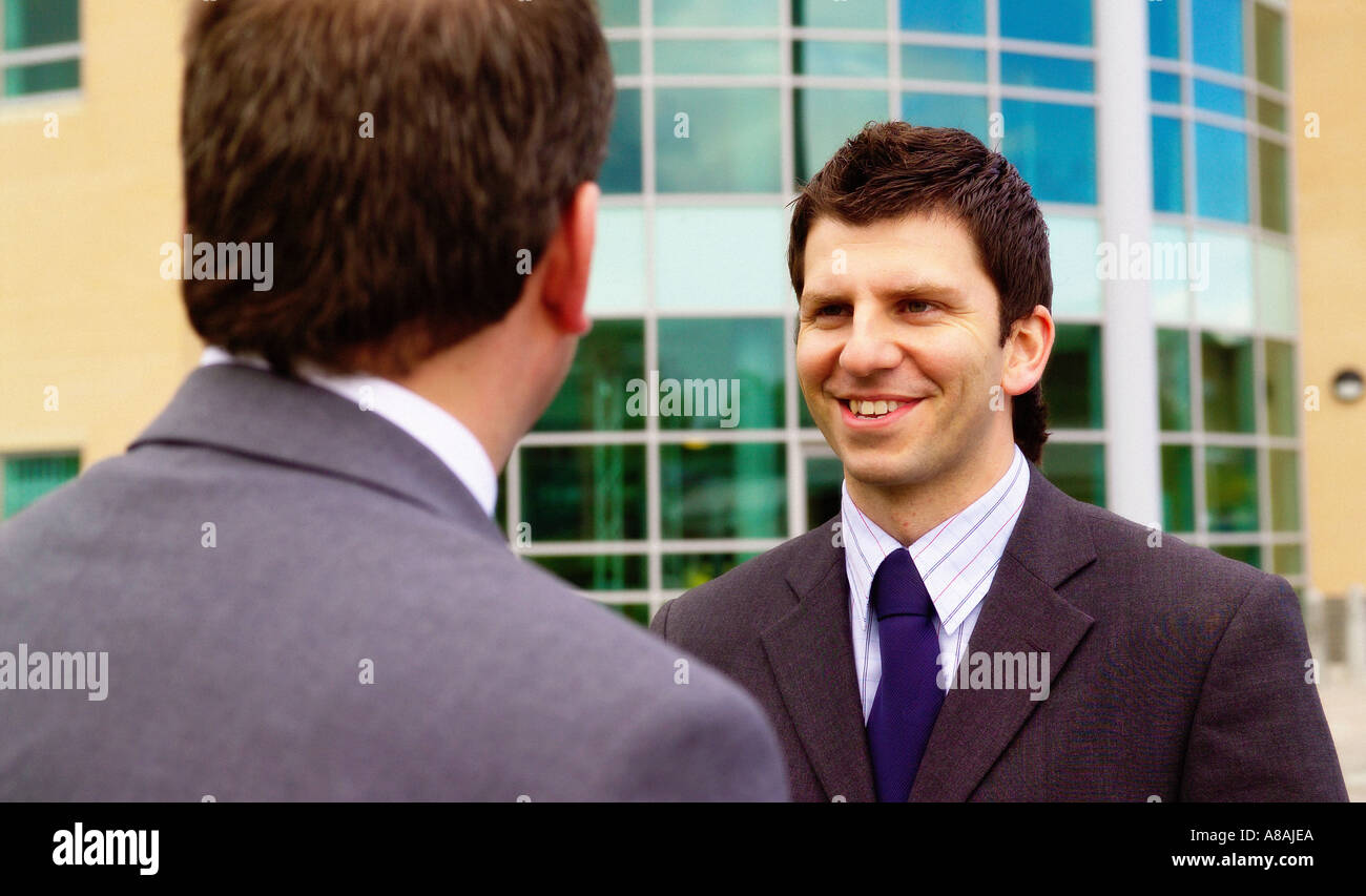 Head and shoulder shot of two men wearing suits, one facing the camera ...