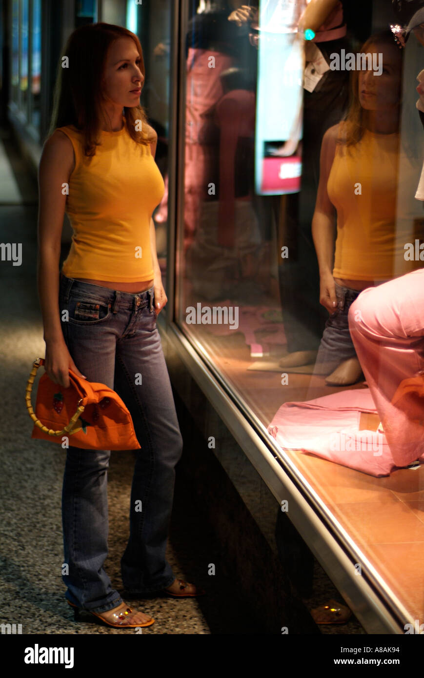Young Woman Window Shopping During the Evening Stock Photo