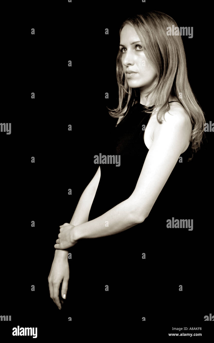 Young Woman in Black Dress Against a Black Background Stock Photo