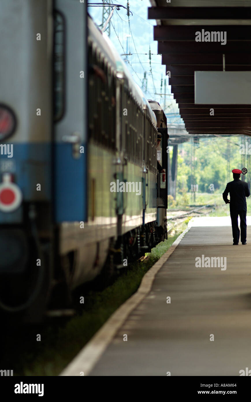 Railway Station Master on the Platform Next to a Train Carriage. Stock Photo