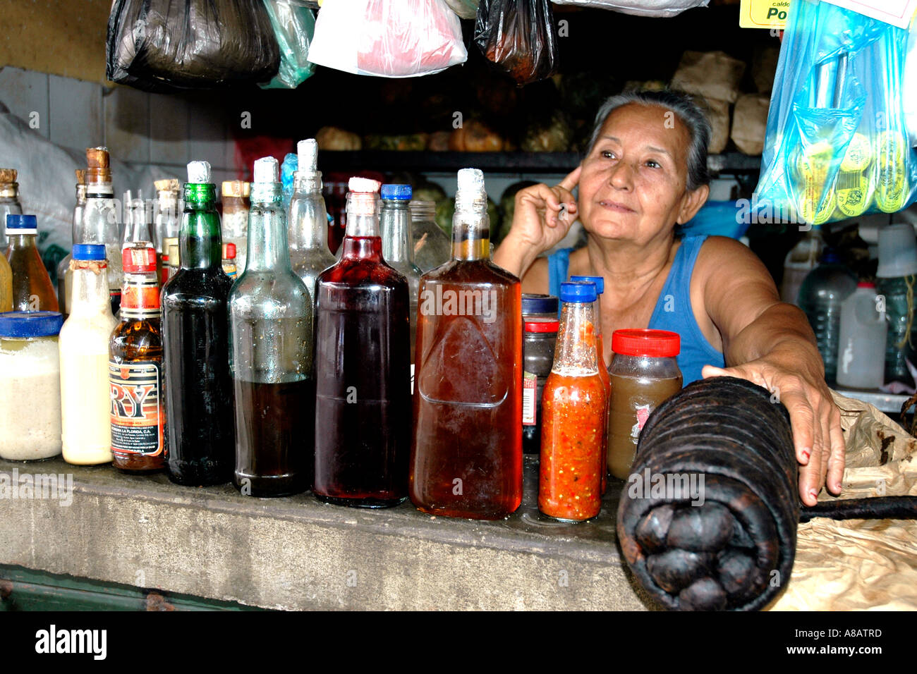 In a market stall in Venezuela's Ciudad Bolivar a woman displays cooking oils and a big black lump of chewing tobacco Stock Photo