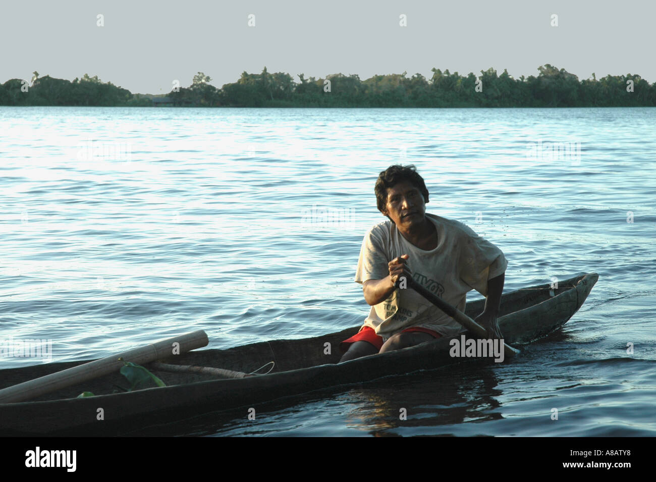 A Warao Indian paddles his canoe in Venezuela's Orinoco river delta as twilight descends Stock Photo