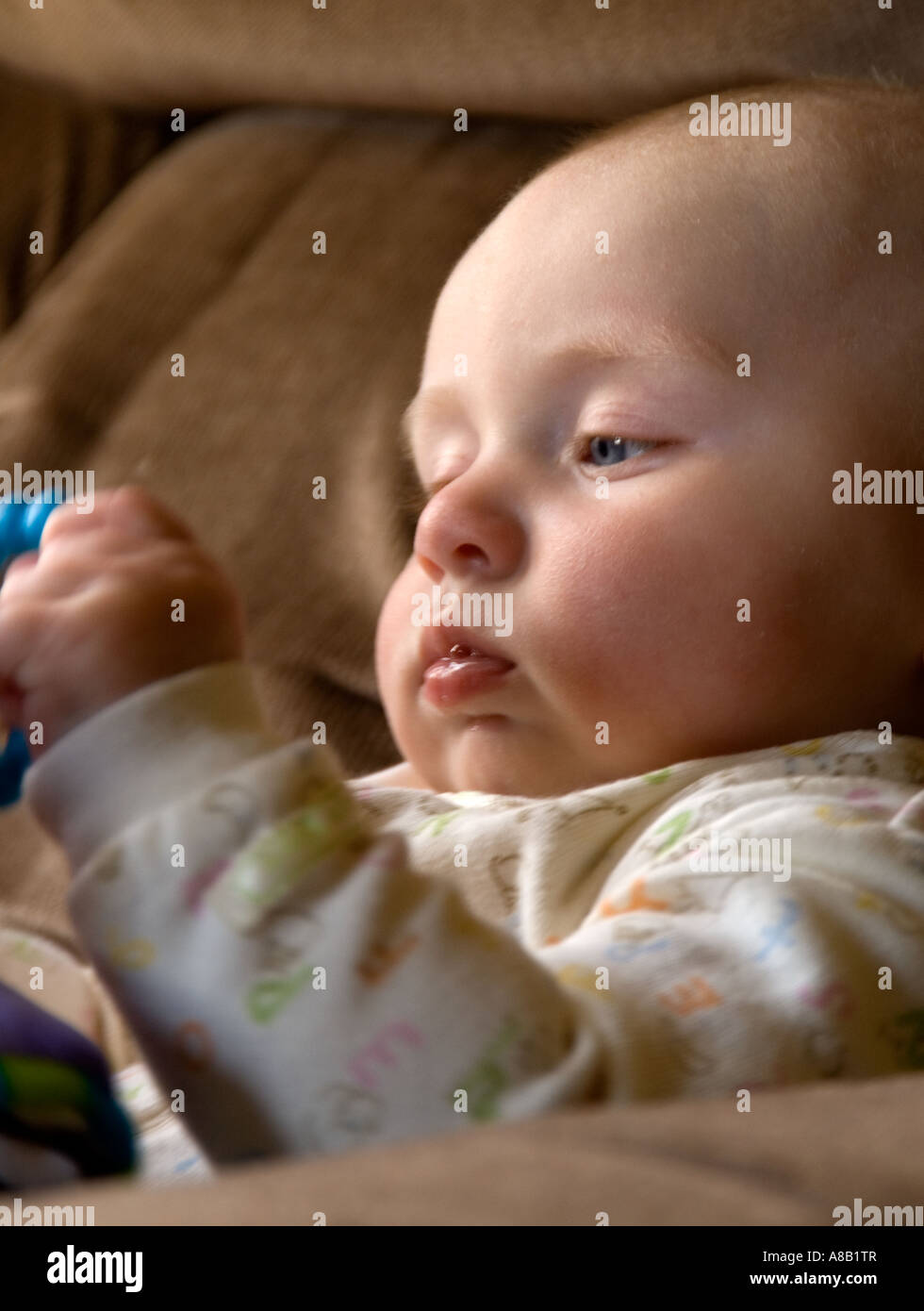 Baby girl learns hand eye coordination Stock Photo
