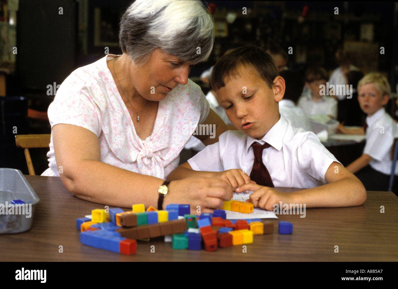 Teacher giving extra help with counting to a dysbraxic child Stock Photo