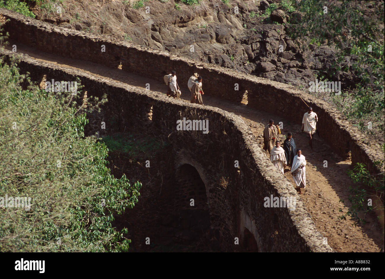 People in traditional dress crossing the Portuguese bridge near the Tis Issat (Blue Nile Falls), Bahar Dar, Ethiopia Stock Photo