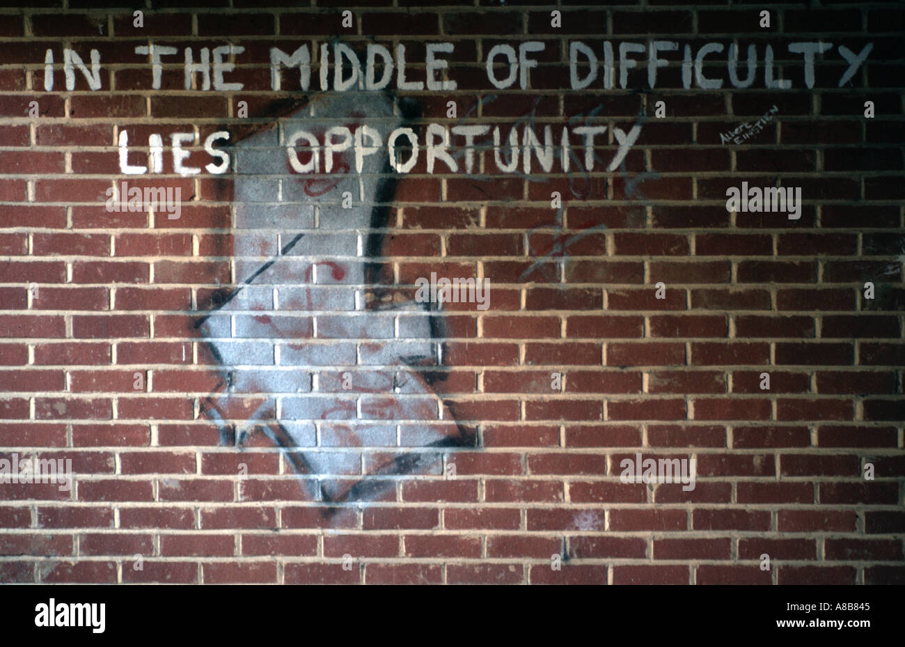 Graffitti on a wall is a quotation by Albert Einstein and reads as follows IN THE MIDDLE OF DIFFICULTY LIES OPPORTUNITY Stock Photo