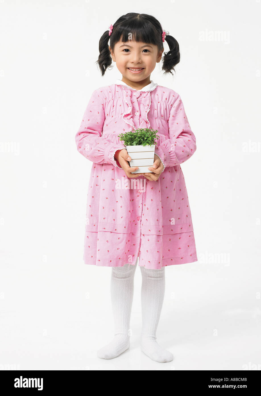 a girl is holding a plant in a flowerpot Stock Photo - Alamy