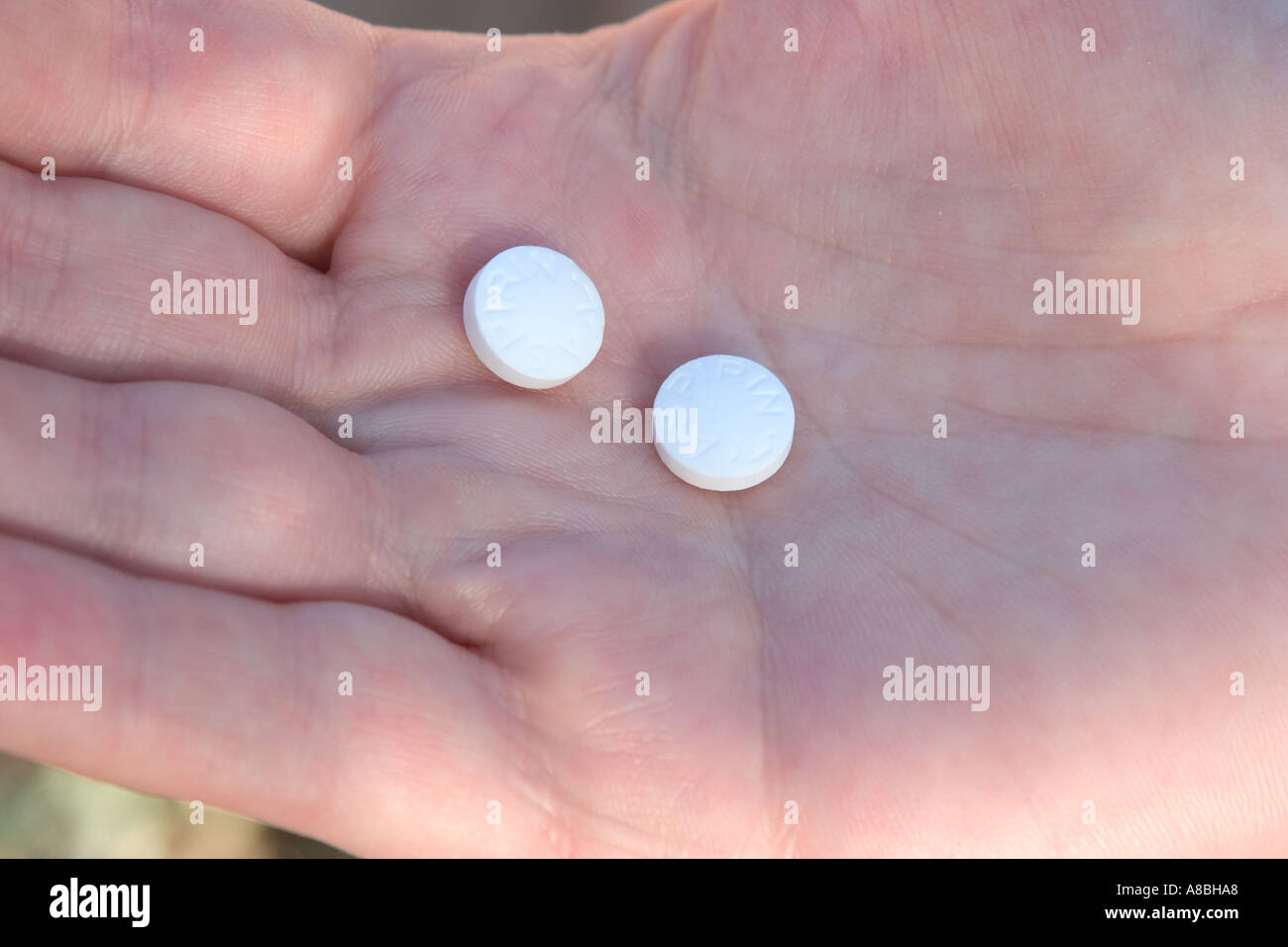 Two aspirin tablets resting in the palm of someone s hand  Stock Photo