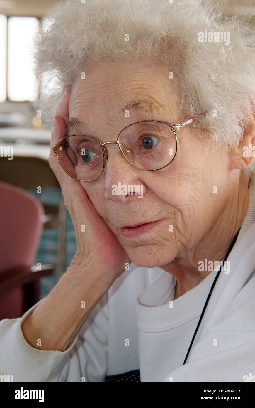 Ageing senior female with hand against face Stock Photo