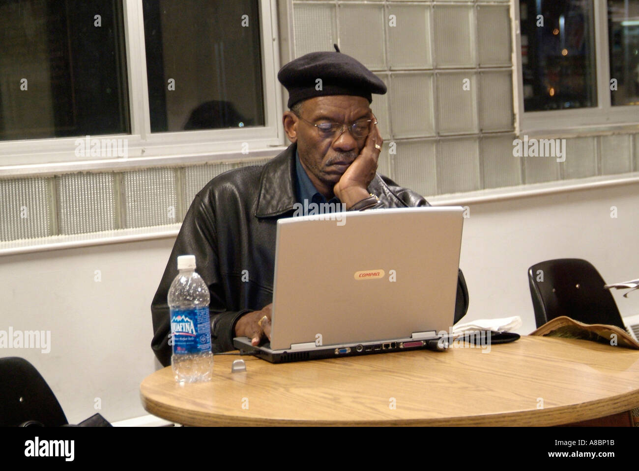 Black male works on laptop computer while waiting for train in Toledo Ohio Amtrak train station Stock Photo