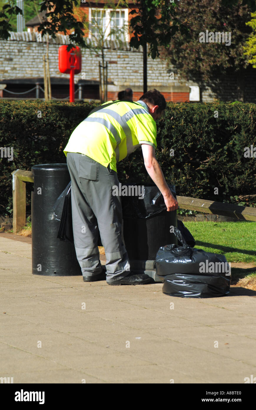 England worker removing full litter sack from bin and replacing with a new plastic sack Stock Photo