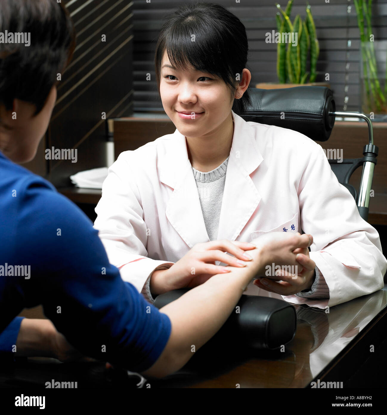 Chinese medicine oriental medicine female doctor examine patient Stock