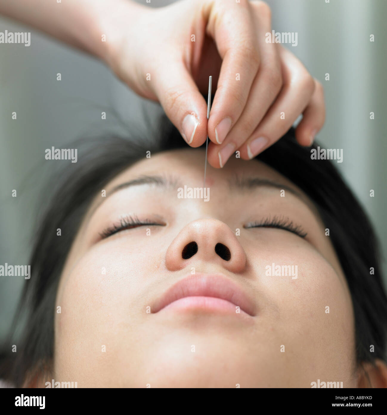Chinese medicine oriental medicine hand applying acupuncture on patient