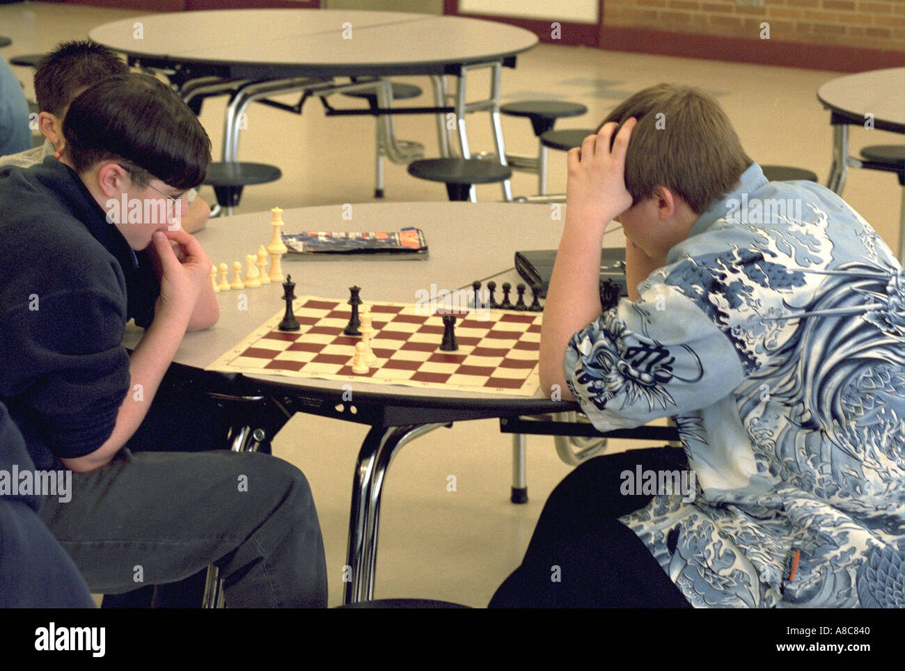 Students playing a competitive game of chess in school study hall age 14. Golden Valley Minnesota USA Stock Photo
