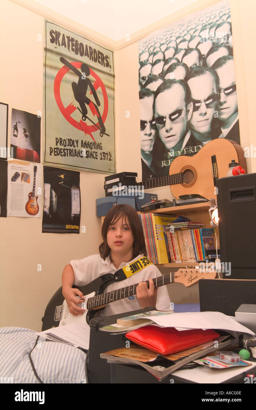 12 Year Old Boy Practising Guitar In His Bedroom Stock Photo