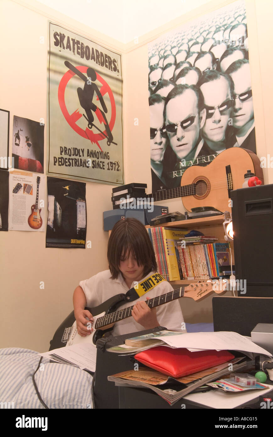12 Year Old Boy Practising Guitar In His Bedroom Stock Photo