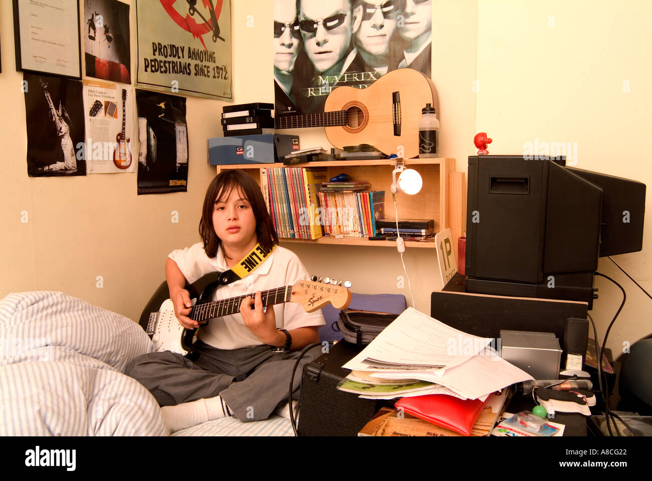 12 Year Old Boy Practising Guitar In His Bedroom Stock Photo