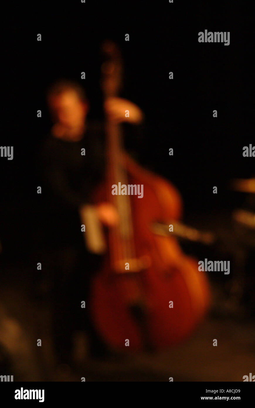 warm out of focus double bass jazz player Stock Photo