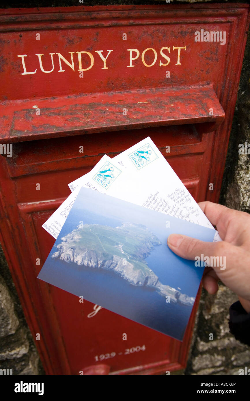 UK Lundy Island posting Lundy stamped postcards in village post box Stock Photo
