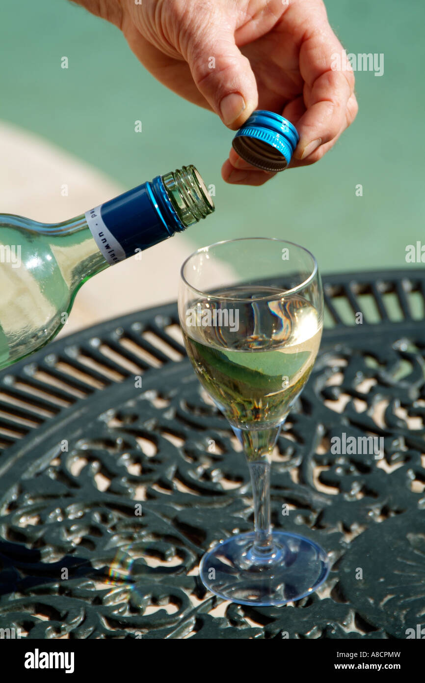 Screw cap on South African wine bottle White wine being poured into a wineglass Stock Photo