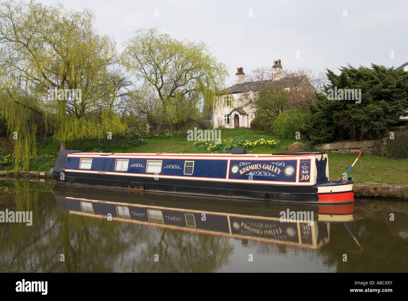 Narrowboat moored on the Macclesfield canal by a canalside dwelling Stock Photo