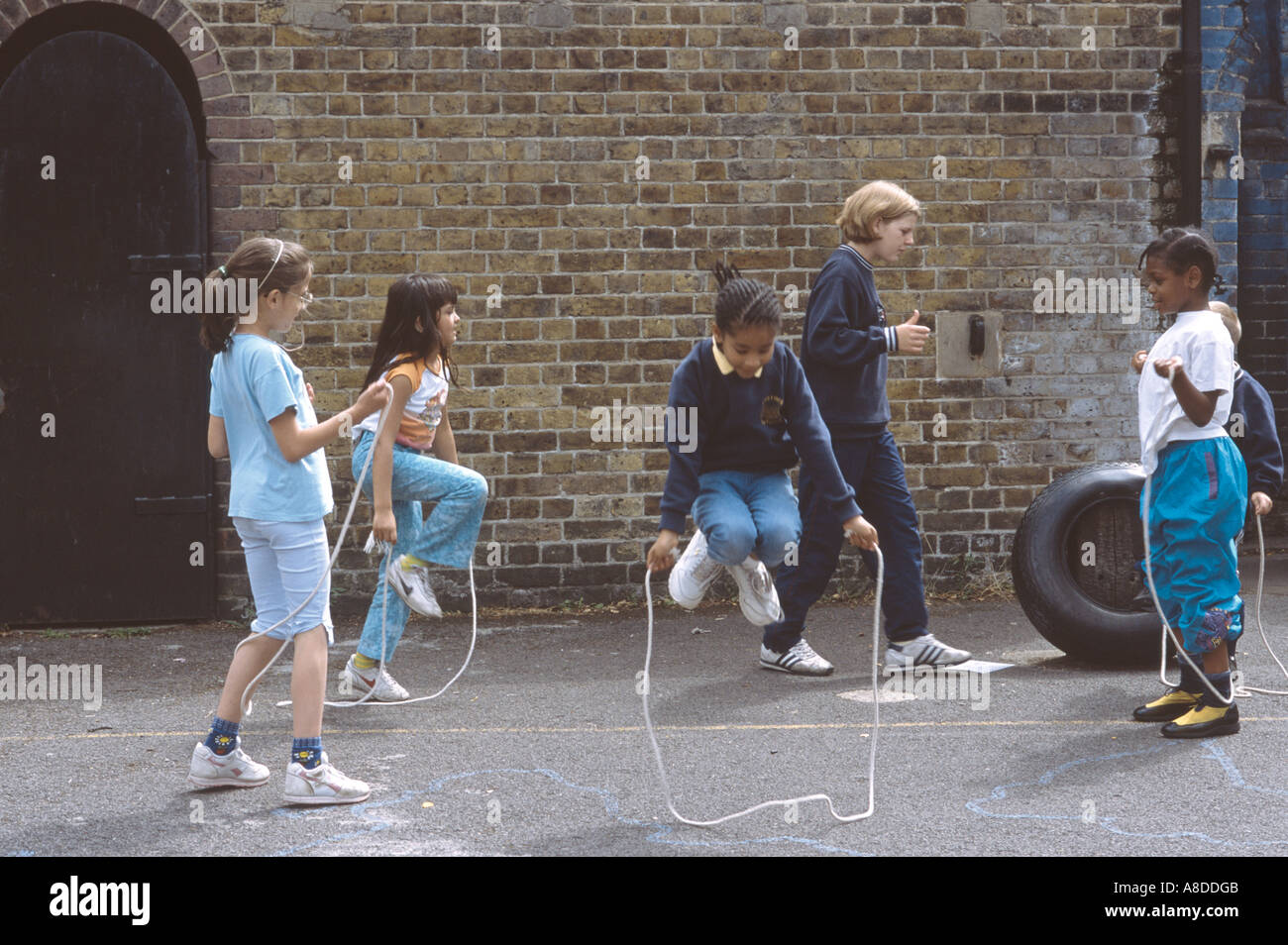 Primary school playground with girls skipping rope Stock Photo Alamy