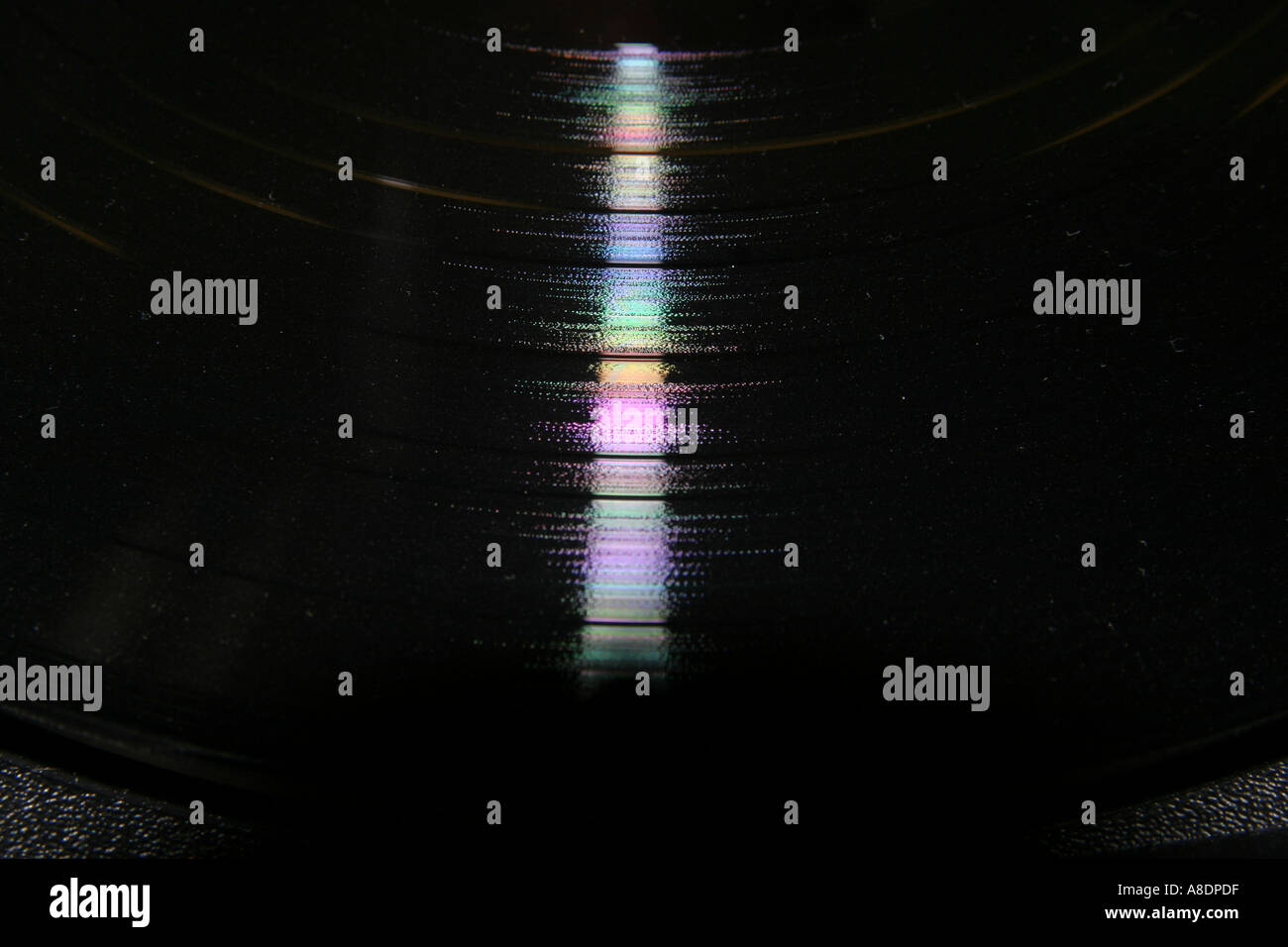 Colour reflections in the narrow tracks of an old vinyl LP record Stock Photo