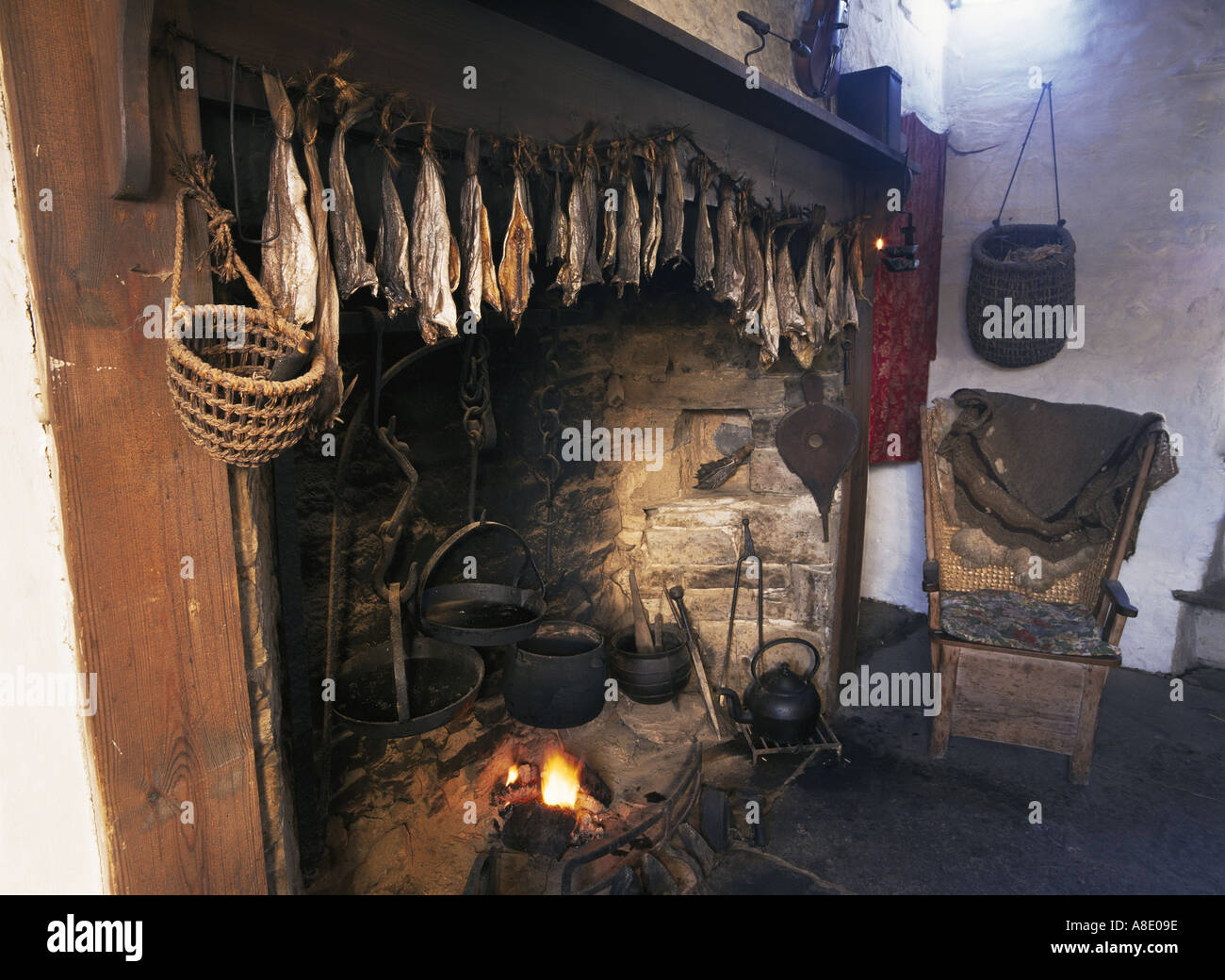 dh Farm museums Scotland CORRIGALL MUSEUM ORKNEY ISLES Dried smoked fish above fireplace chair house fire drying Farmhouse interior old stone cottage Stock Photo
