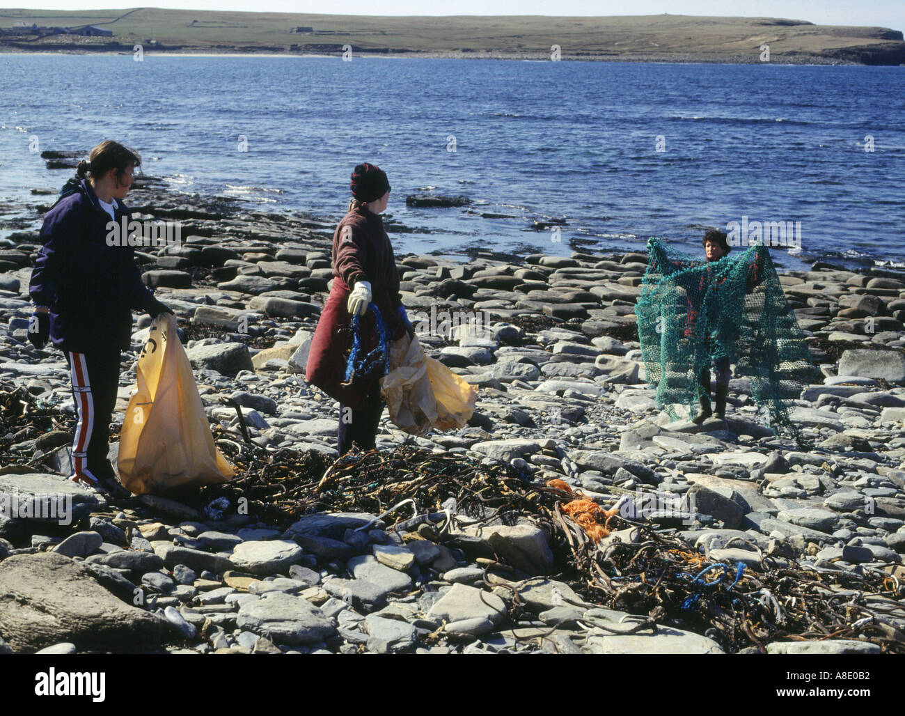 dh Bagging the Bruck ENVIRONMENT ORKNEY Women filling bags beach waste clearing rubbish teenagers cleaning uk clean up youth scotland people trash Stock Photo