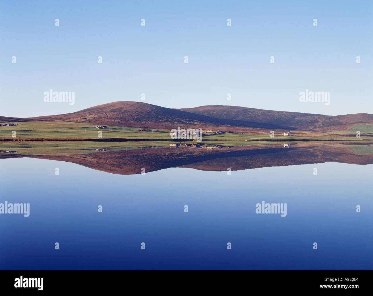 dh Kirbister Loch Scotland ORPHIR ORKNEY Cottages scenic tranquil blue sky reflection water clear quiet still peaceful house scenery islands Stock Photo