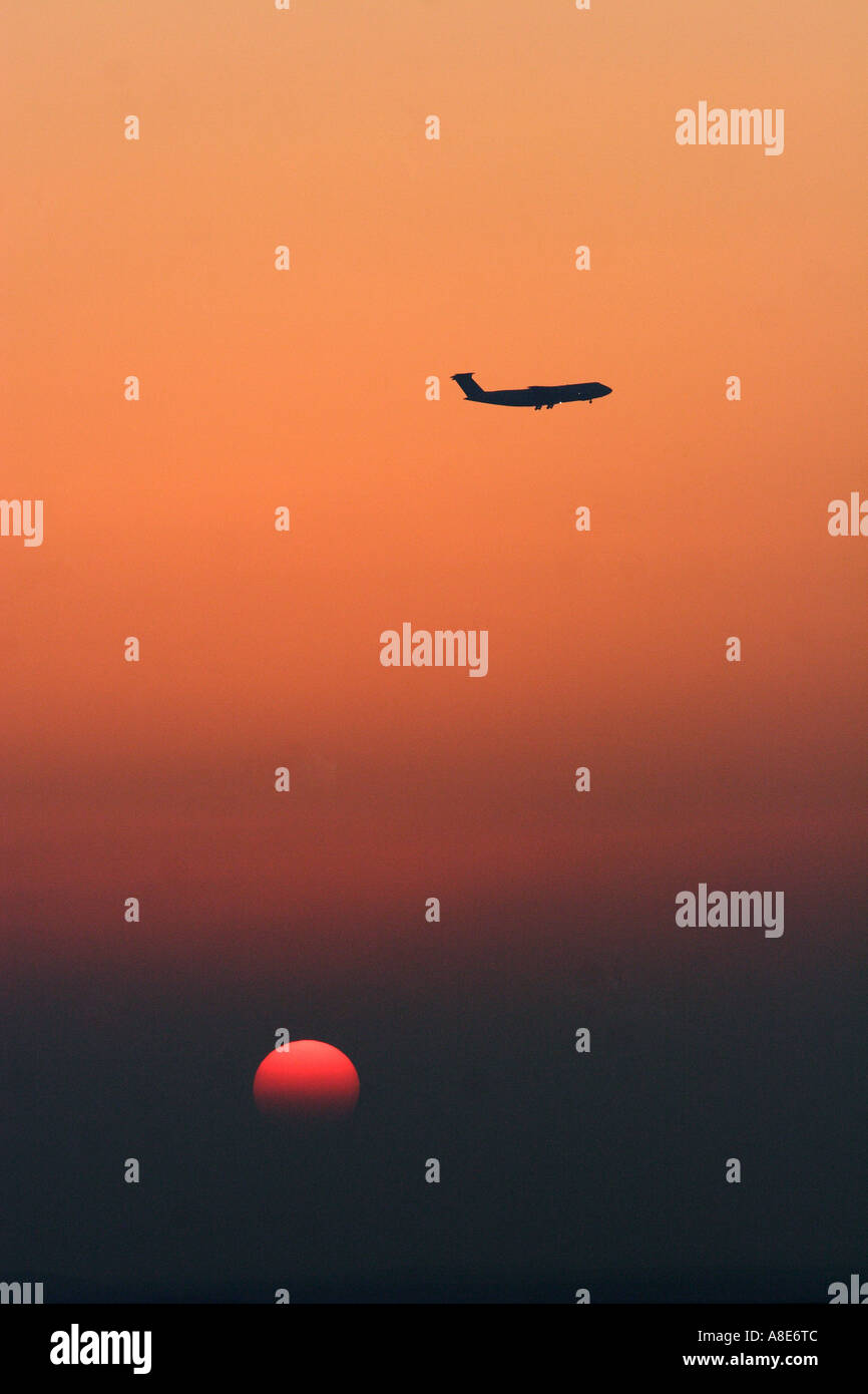 A plane flys over a sunset in Qatar Stock Photo