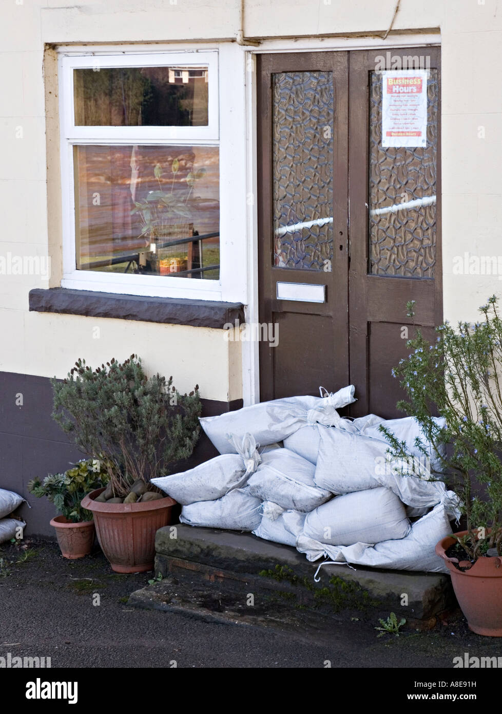 Sandbags across pub door after flood warning on river Usk Abergavenny Wales UK Stock Photo