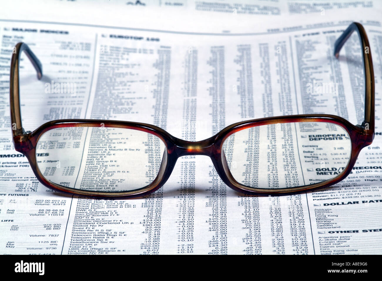 checking list of stocks and shares markets in detail on newspaper page equity prices lens lenses