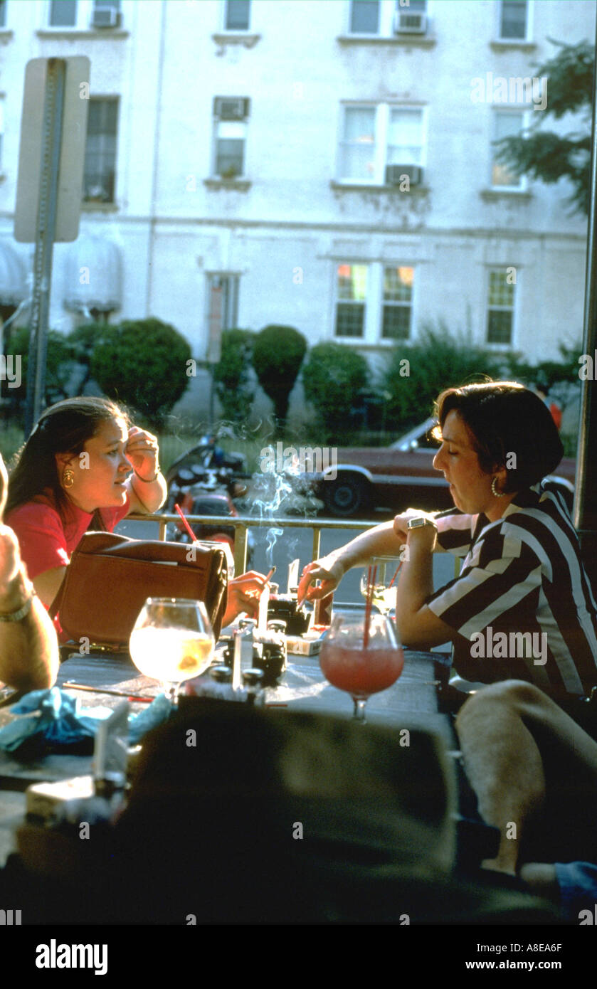 Women age 28 smoking in an outdoor Mexican restaurant. Washington DC District of Columbia USA Stock Photo