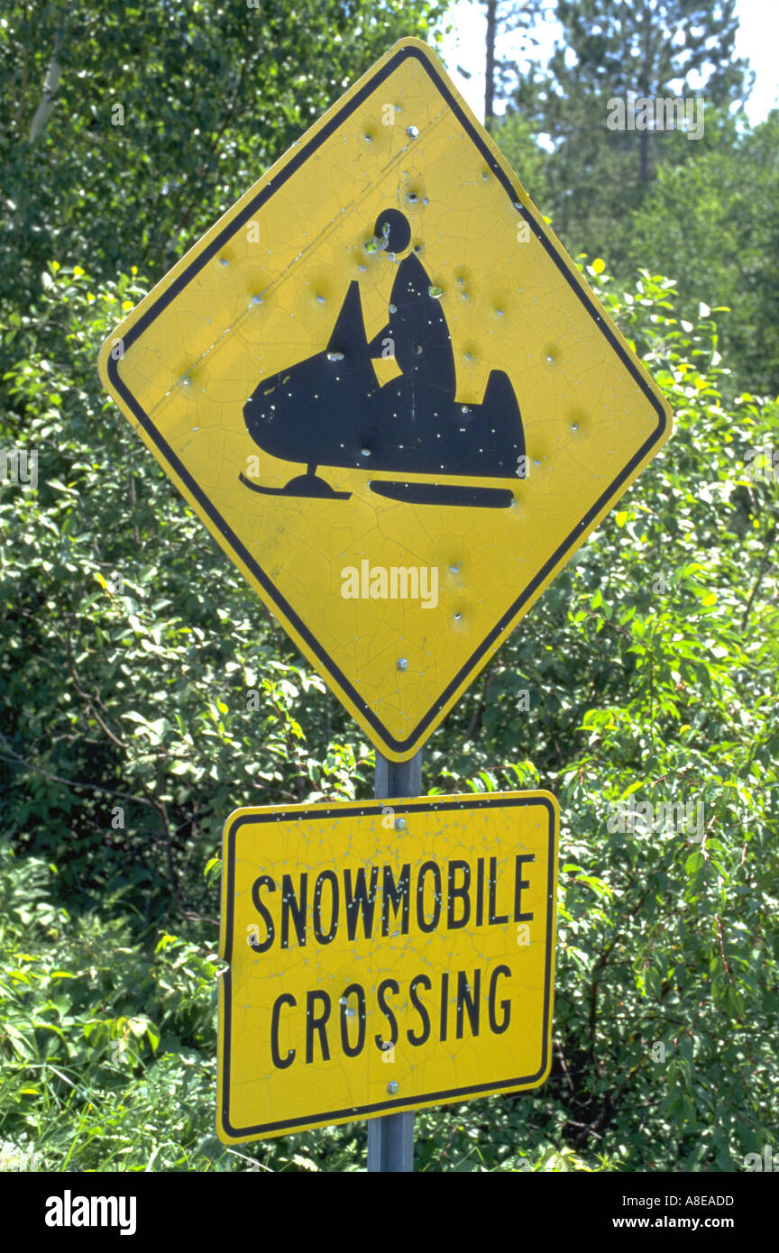 Snowmobiling sign filled with gunshot bullet holes near Gull Lake
