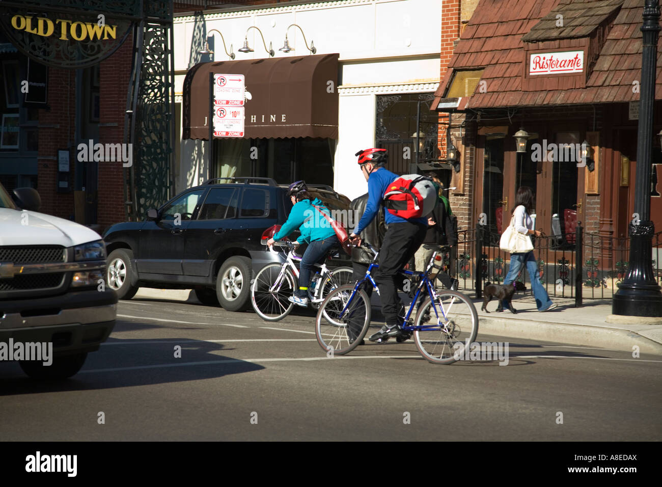 CHICAGO Illinois Two bicyclists in bike lane on Wells Street pedestrians on sidewalk in Old Town