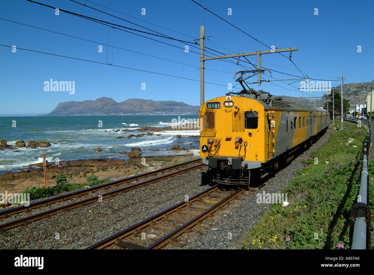Coastal train on railway from Simons Town to Cape Town city passes St