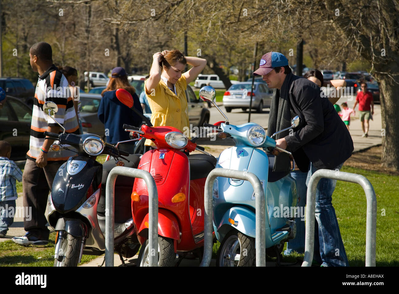 CHICAGO Illinois Young couple park Vespa scooters at rack near Lincoln Park Zoo Stock Photo